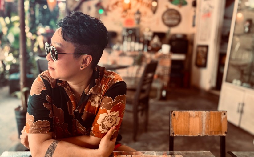 Minh sitting in a coffeeshop in Hue, Vietnam, looking off to the left.